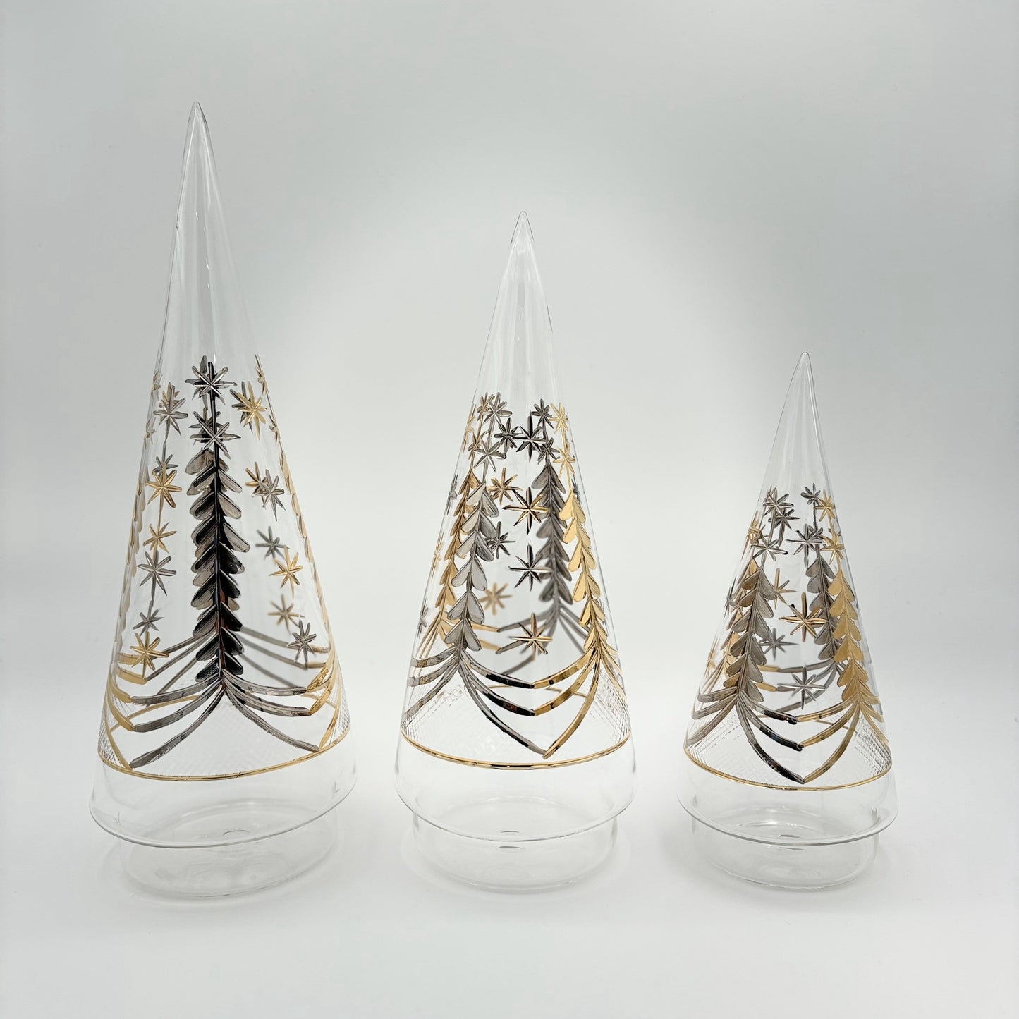 Decorative handblown glass cone shpaed trees with gold and silver star and leaf patterns in three sizes