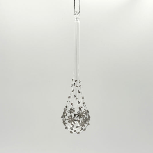 Clear handblown glass teardrop-shaped ornament with star-like platinum colored decorations
