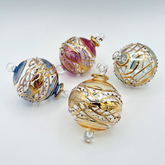 Decorative handblown glass Christmas ornaments with intricate engraved designs and gold hilghlights