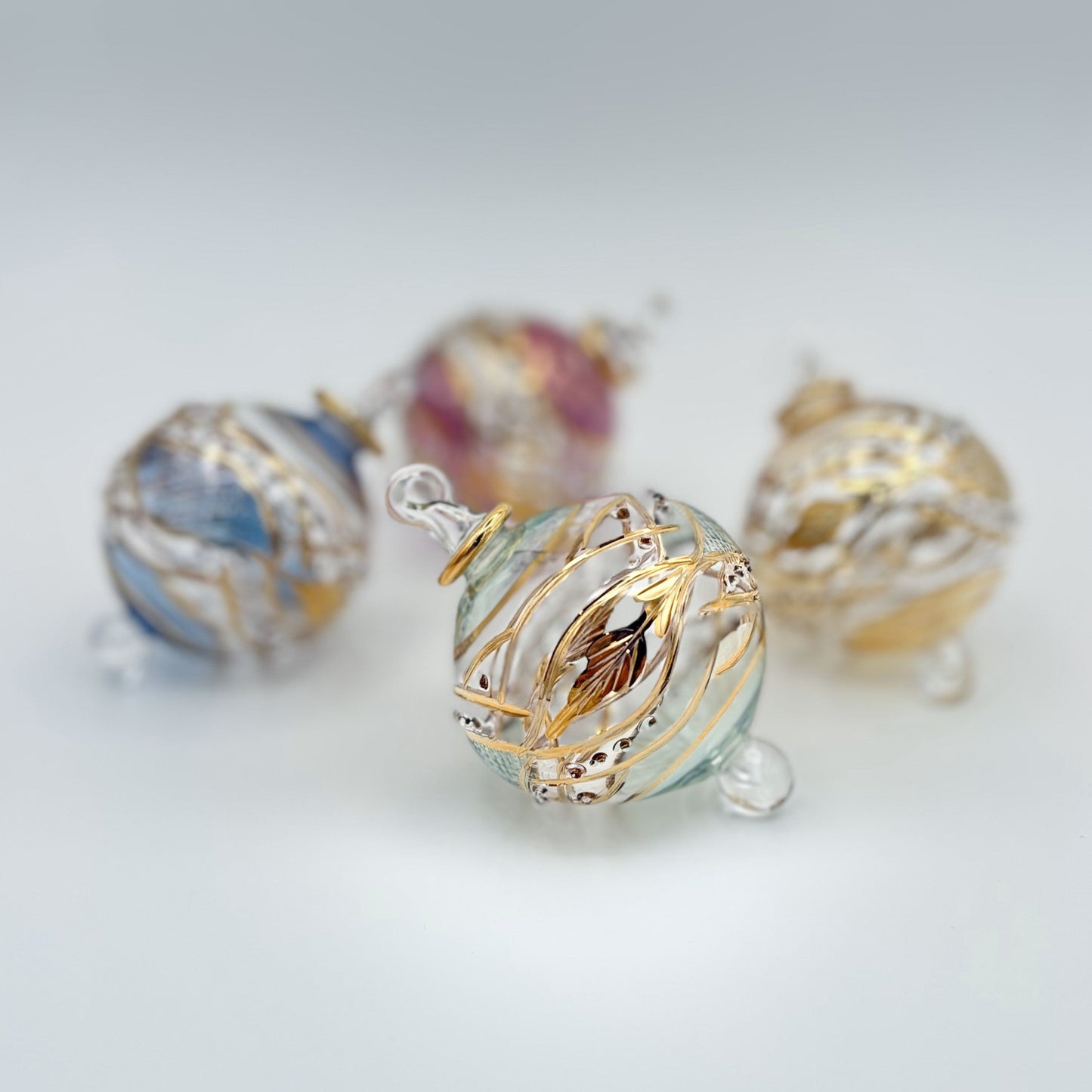 Decorative handblown glass Christmas ornaments with intricate designs and gold hilghlights