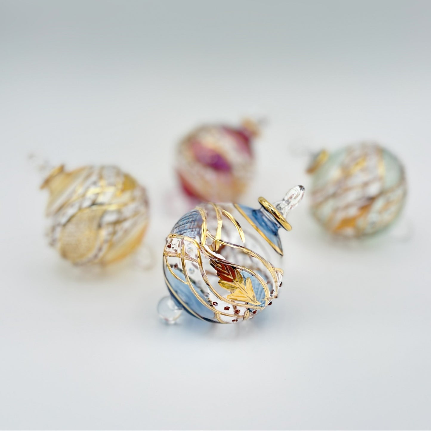 Decorative handblown glass Christmas ornaments with intricate designs and gold hilghlights