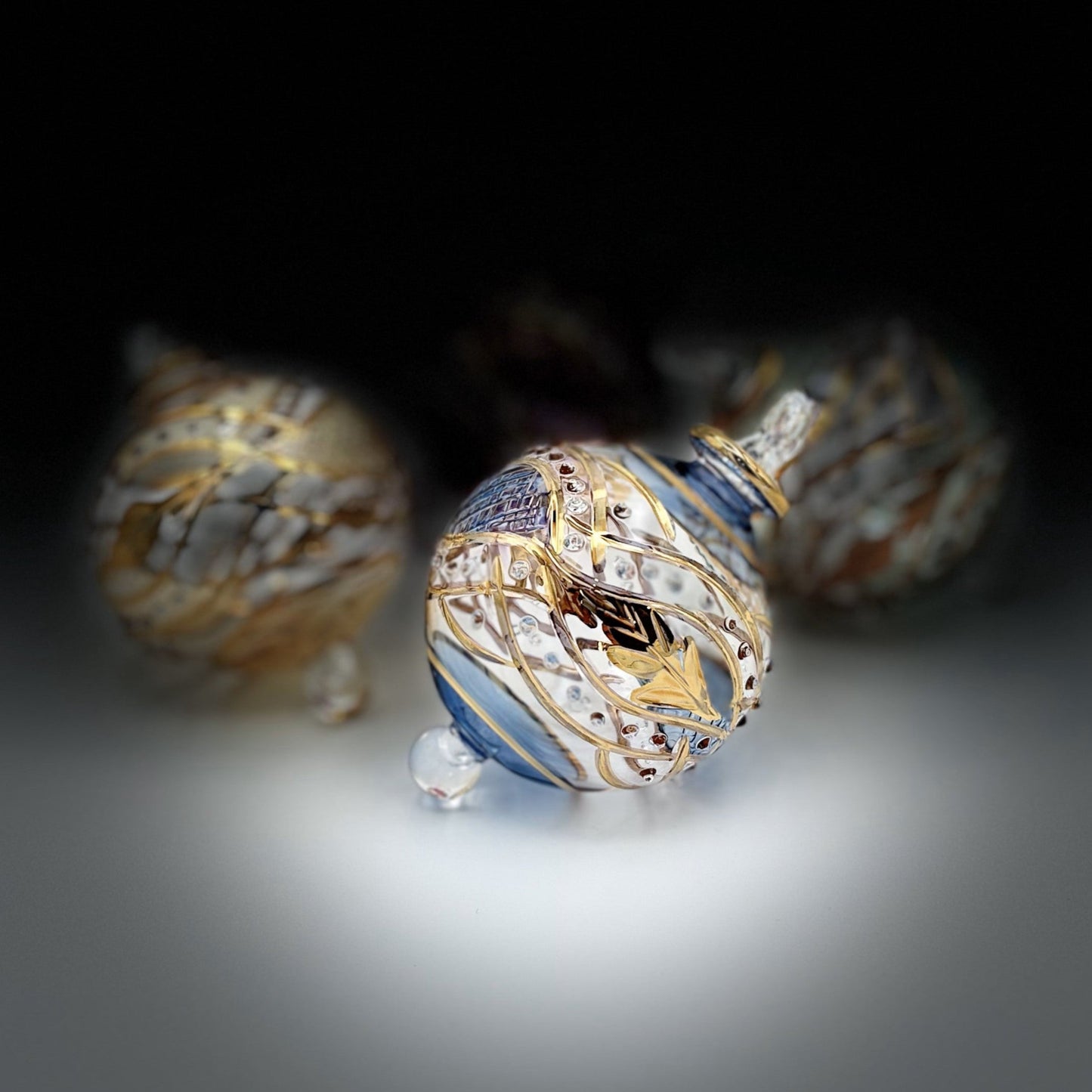 Decorative handblown glass Christmas ornaments with intricate designs and gold hilghlights