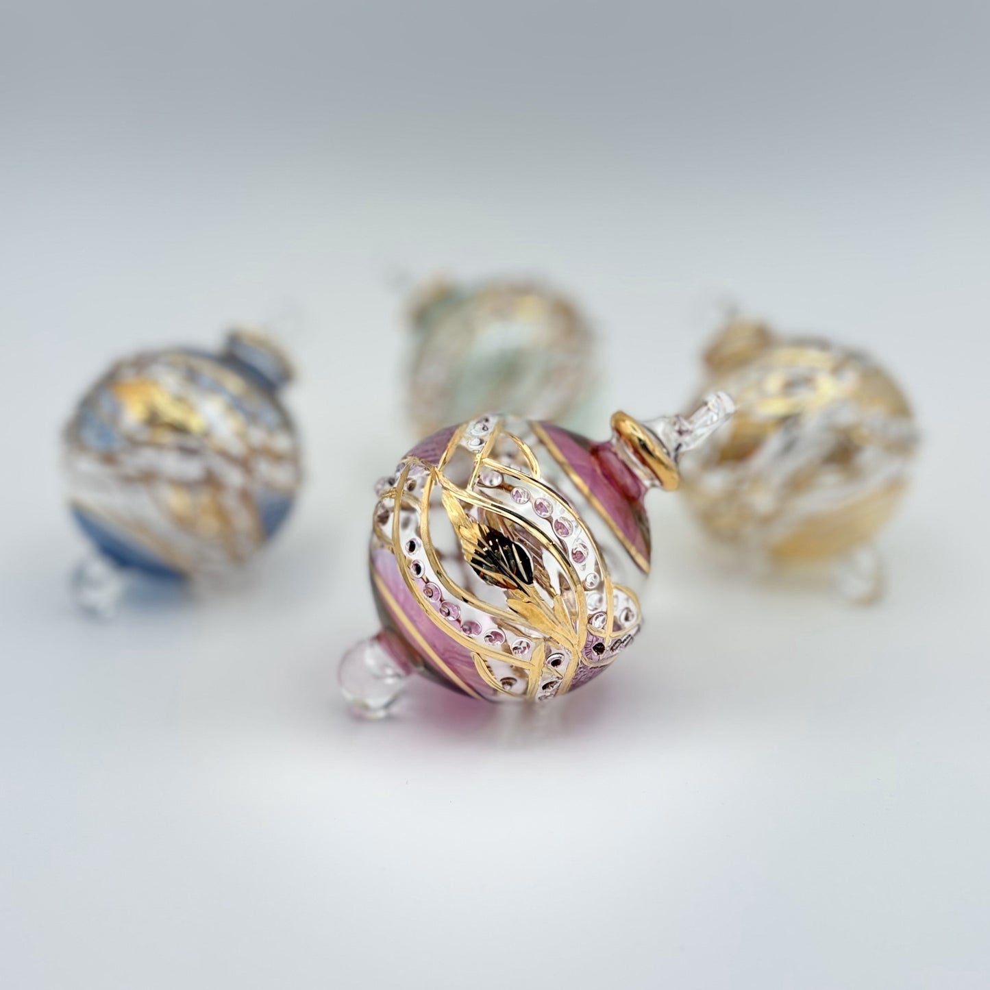 Decorative handblown glass Christmas ornaments with intricate designs and gold hilghlights
