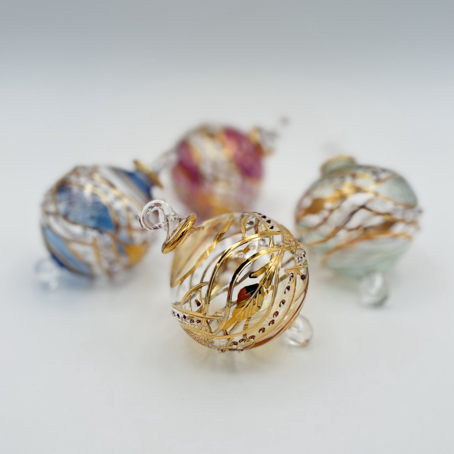 Decorative handblown glass Christmas ornaments with intricate designs and gold hilghlights