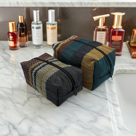 Striped eco-friendly toiletry bags handwoven of upcycled plastic on a marble surface
