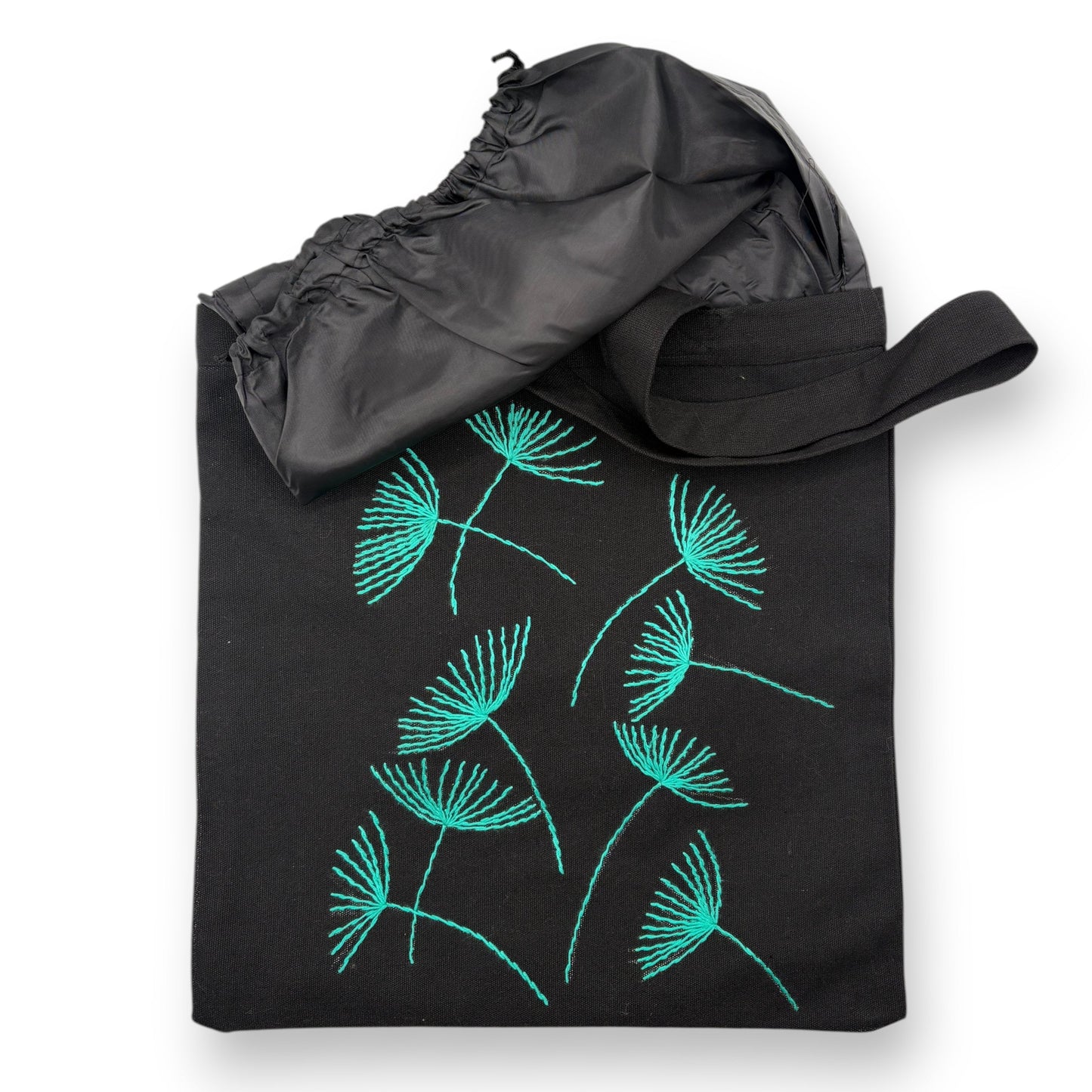 Black tote bag with hand-embroidered turquoise papyrus floral patterns