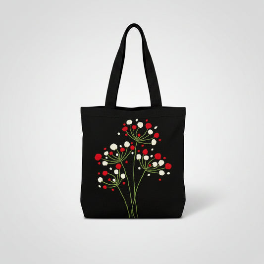 Handmade black tote bag with hand-embroidered red and white floral design, fair trade artisan-made, ethical fashion