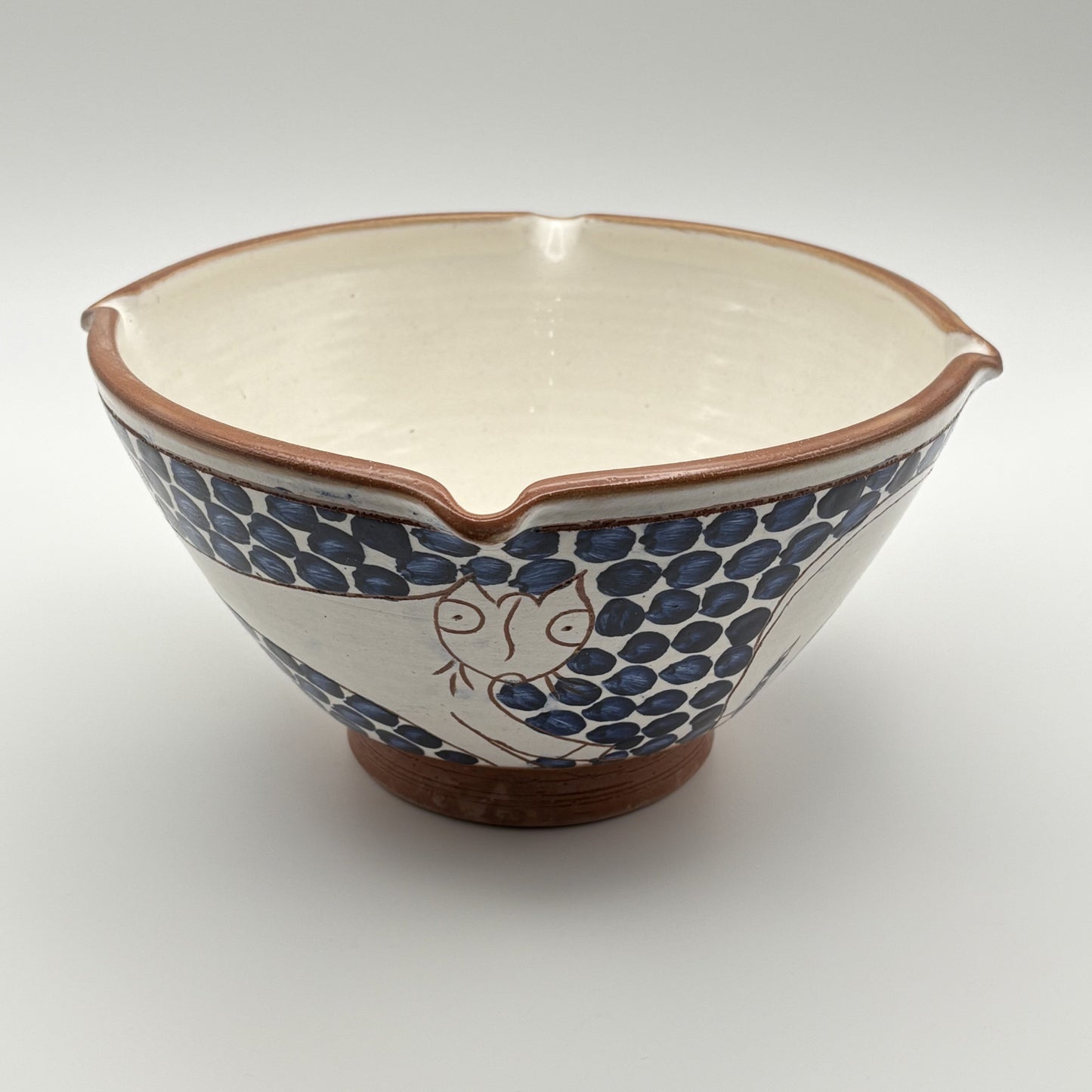 Handmade fair trade ceramic bowl with bouncing cat on a blue and white floral design