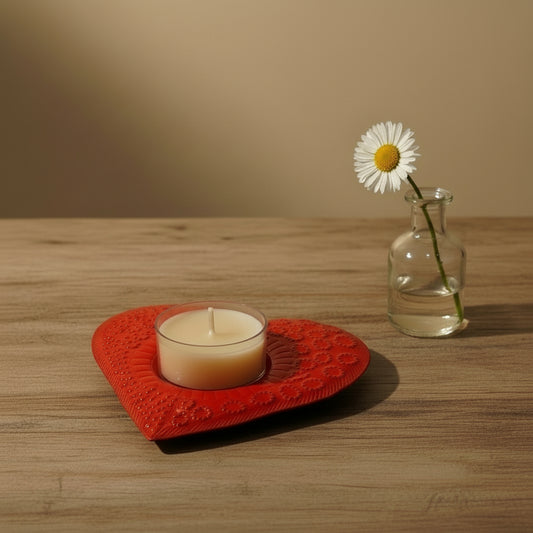 Heart-shaped handmade upcycled metal candle holder with a candle painted in red, ethically handcrafted