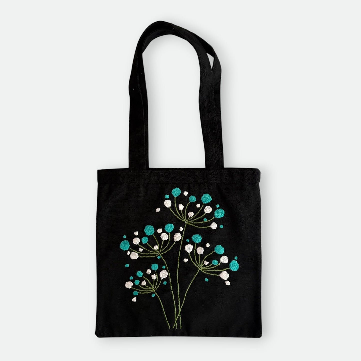 Handmade black tote bag with hand-embroidered white and turquoise hydrangea, fair trade