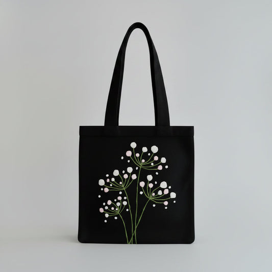Handmade black tote bag with hand-embroidered white hydrangea, fair trade