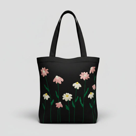Handmade black tote bag with hand-embroidered pink and white marguerite, fair trade