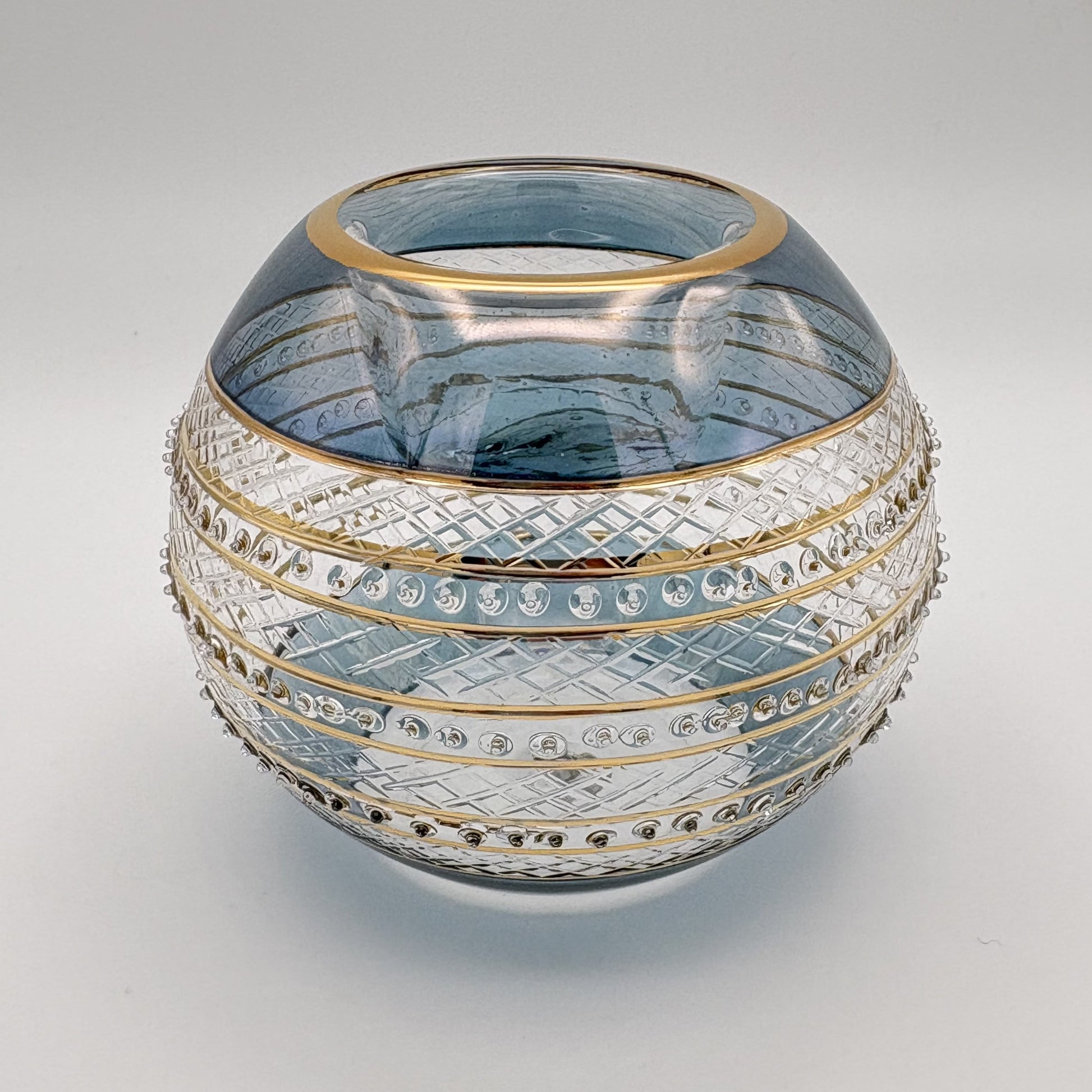 Fair trade handblown glass candle holder with intricate patterns, gold detail and blue rim, ethically handmade