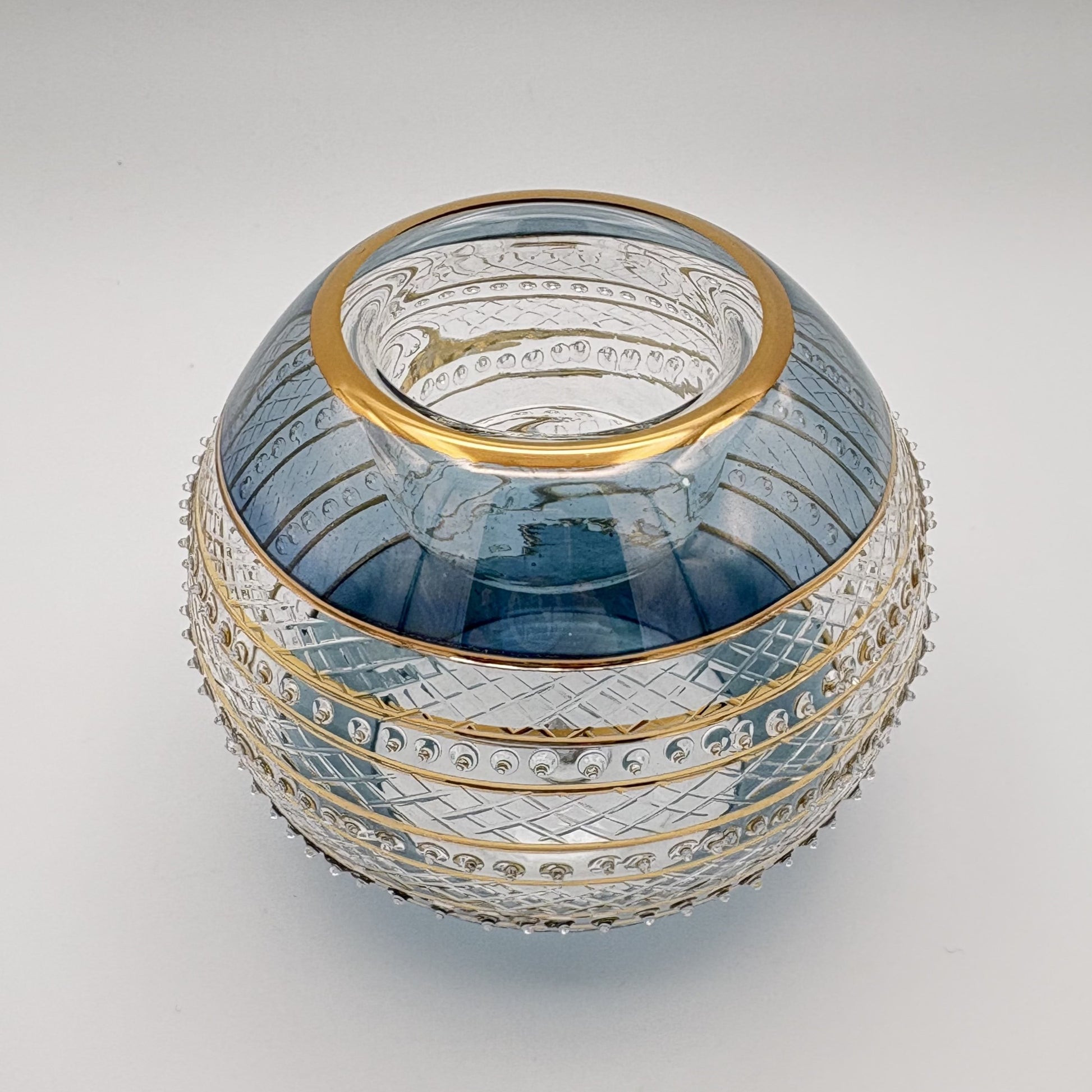 Fair trade handblown glass candle holder with intricate patterns, gold detail and blue rim, ethically handmade