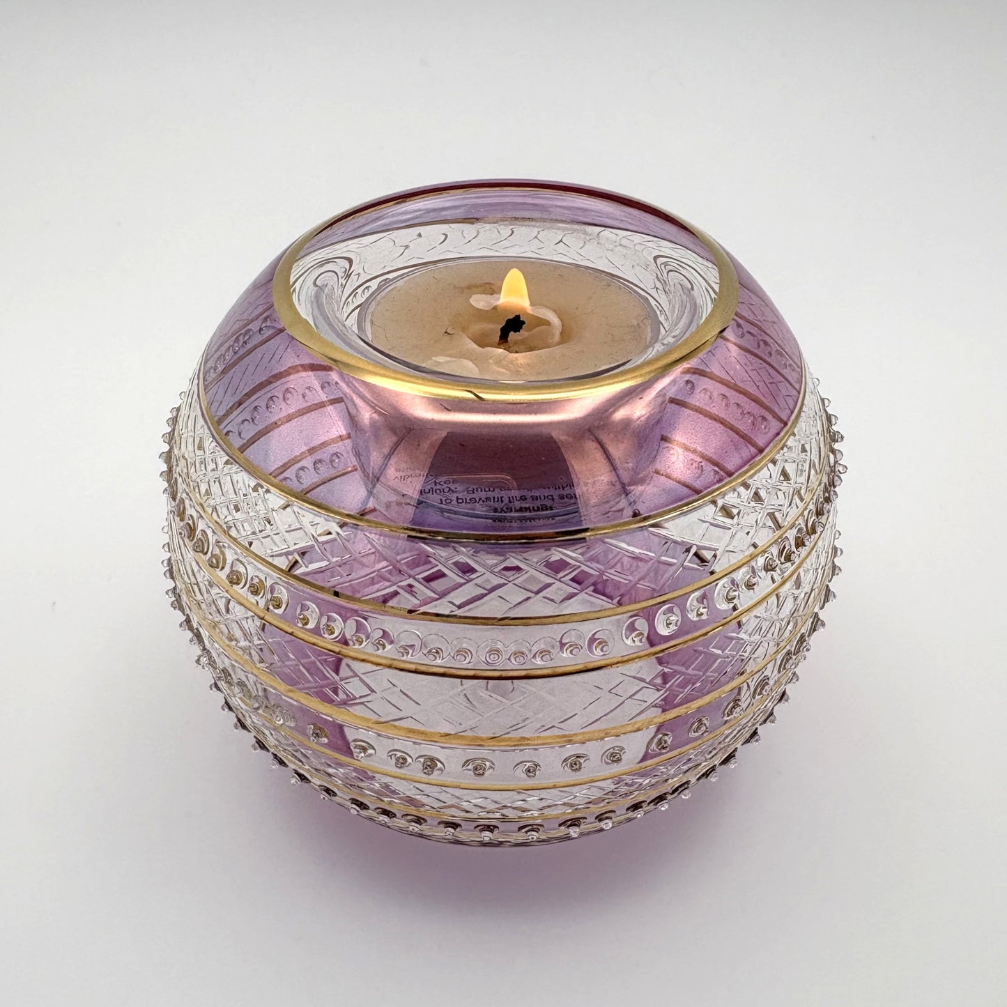 Fair trade handblown glass candle holder with intricate patterns, gold detail and pink rim, ethically handmade