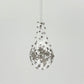 Clear handblown glass teardrop-shaped ornament with star-like platinum colored decorations 