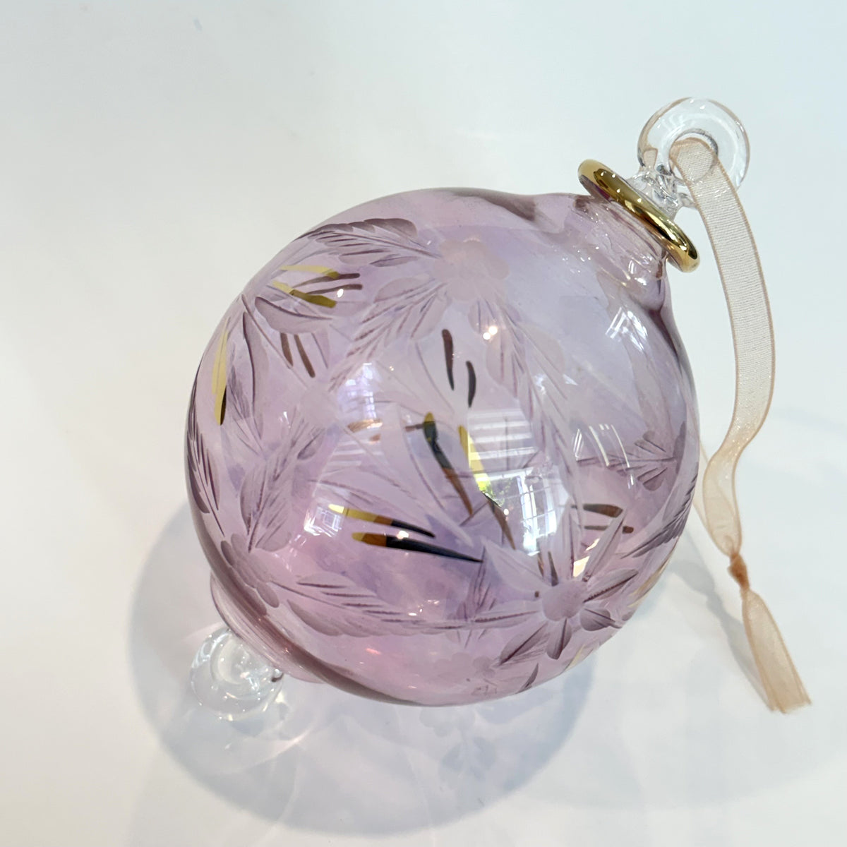 Blown glass bauble ornament with a pink tint and gold detail, featuring etched flowers