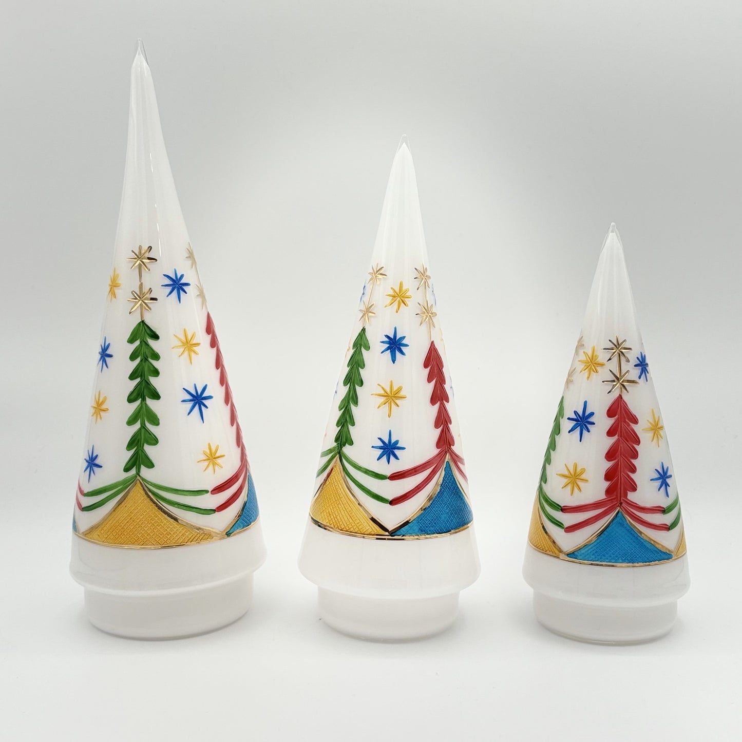Three decorative tabletop white handblown glass cone-shaped Christmas trees with colorful tree designs, fair trade, ethically made