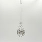 Clear handblown glass teardrop-shaped ornament with star-like platinum colored decorations 