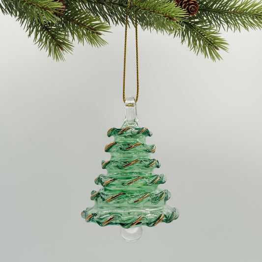 Green blown glass Christmas tree ornament hanging from a branch with pine cones.