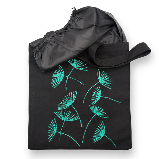 Black tote bag with hand-embroidered turquoise papyrus floral patterns