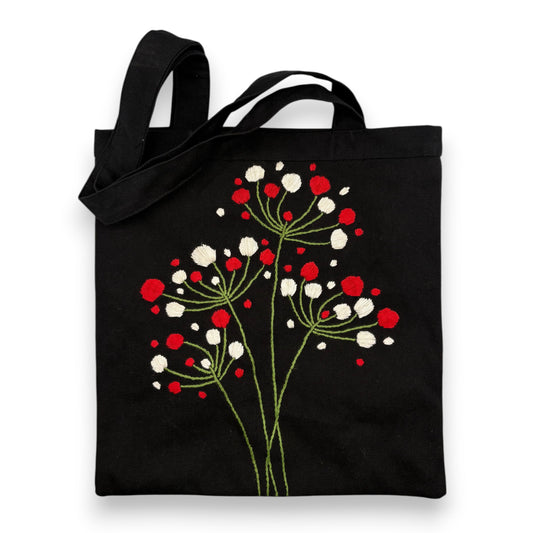 Black tote bag with hand-embroidered floral pattern with red and white berries