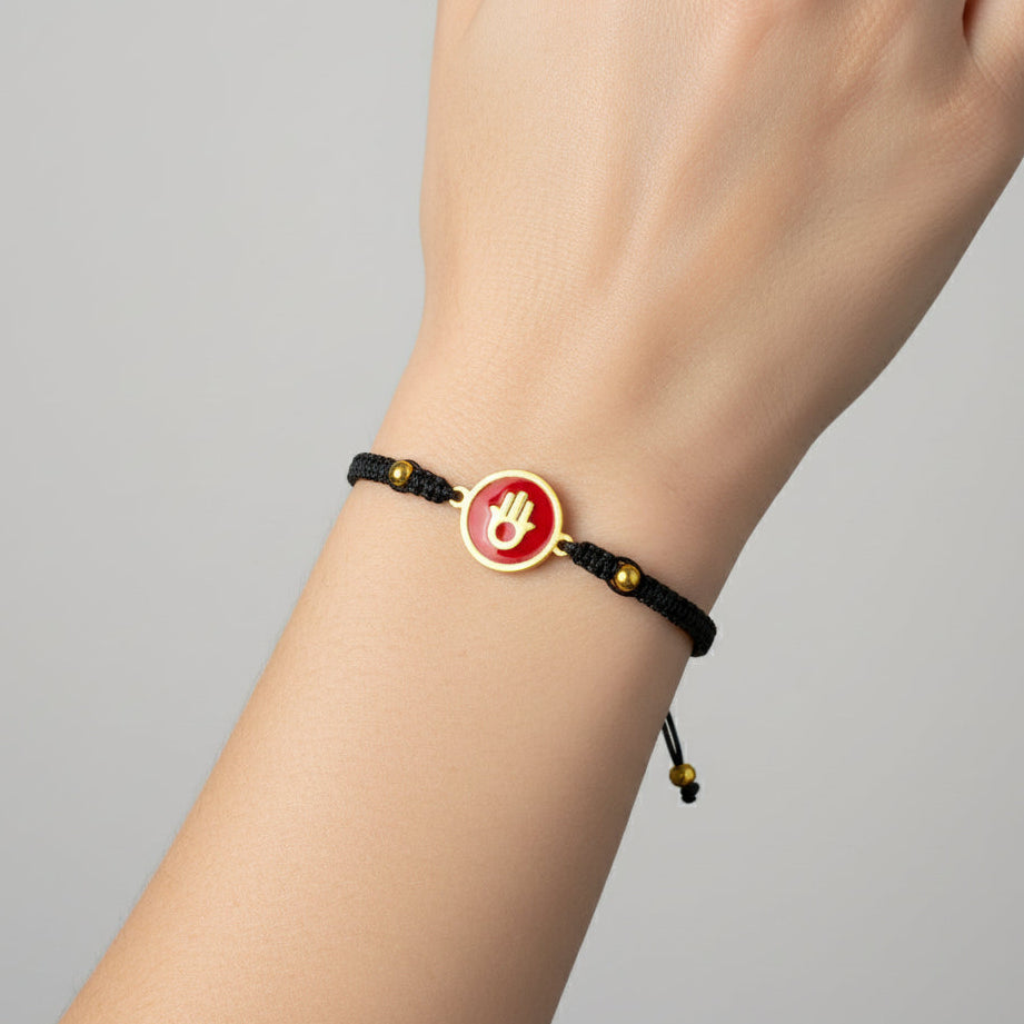 Handmade brass bracelet with a Hamsa symbol on a maroon red enamel background