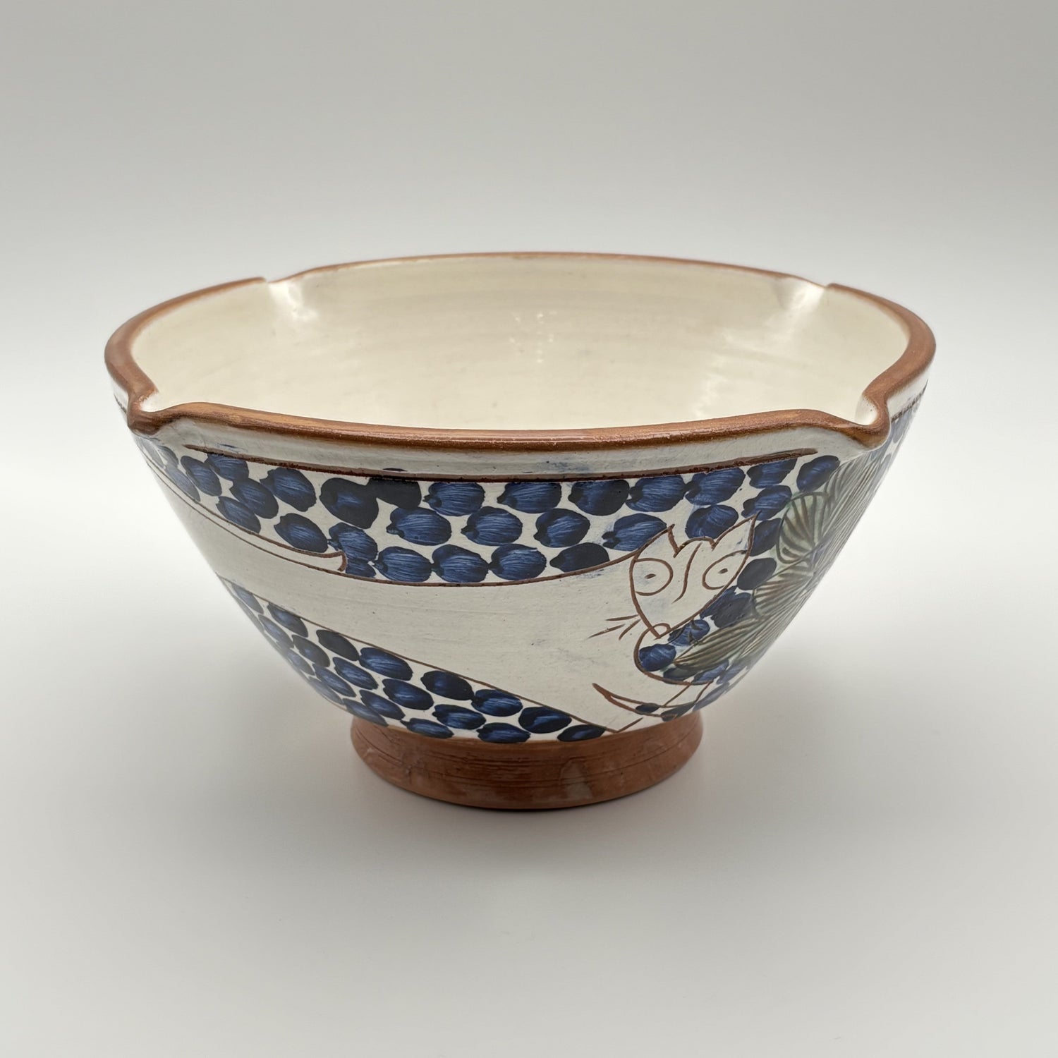 Handmade fair trade ceramic bowl with bouncing cat on a blue and white floral design