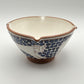 Handmade fair trade ceramic bowl with bouncing cat on a blue and white floral design