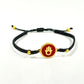 Handmade brass bracelet with a Hamsa symbol on a maroon red enamel background