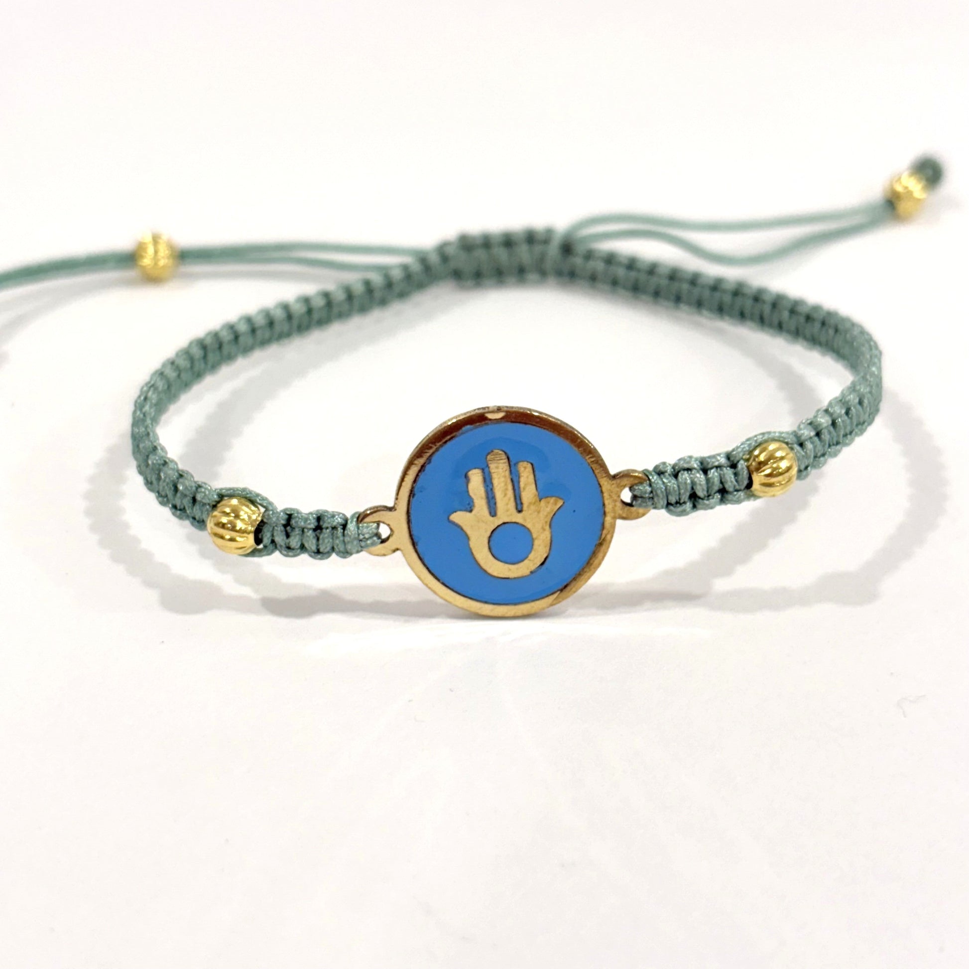 Handmade brass bracelet with a Hamsa symbol on a turquoise enamel background, fair trade, ethically handcrafted