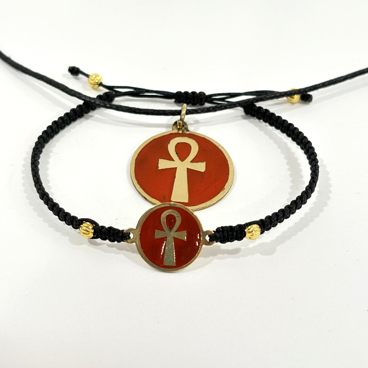 Necklace and bracelet with a maroon red medallion charm featuring a gold ankh symbol, handmade of brass