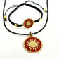 Necklace with a handmade brass pendant featuring gold sun against maroon enamel and black macrame bracelet with matching medallion, fair trade