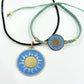 Necklace with a handmade brass pendant featuring gold sun against turquoise enamel and teal macrame bracelet with matching medallion, fair trade