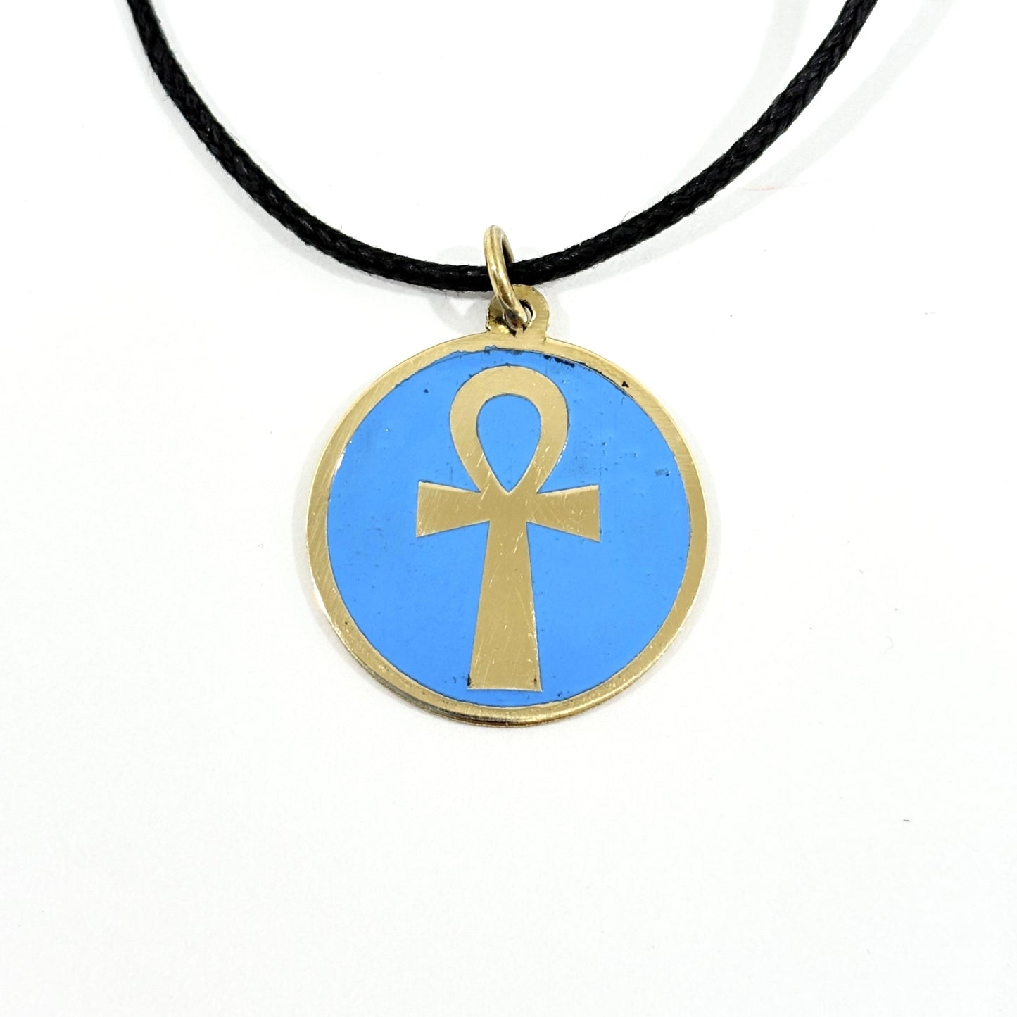 Necklace with a turquoise pendant featuring a gold ankh symbol, handmade of brass