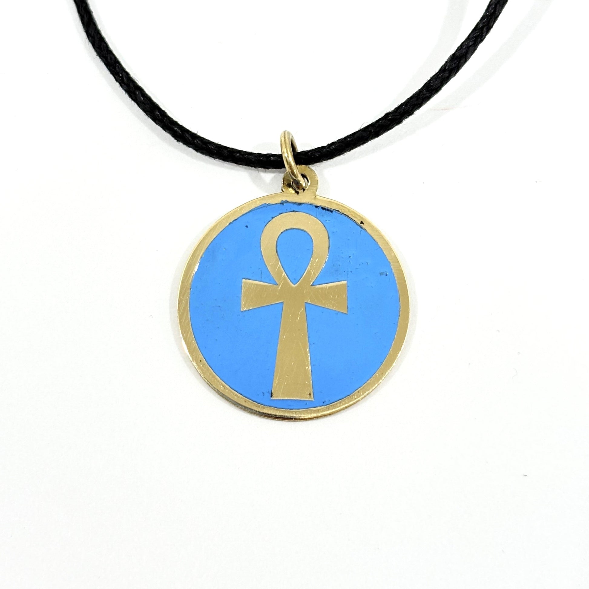 Necklace with a turquoise pendant featuring a gold ankh symbol, handmade of brass