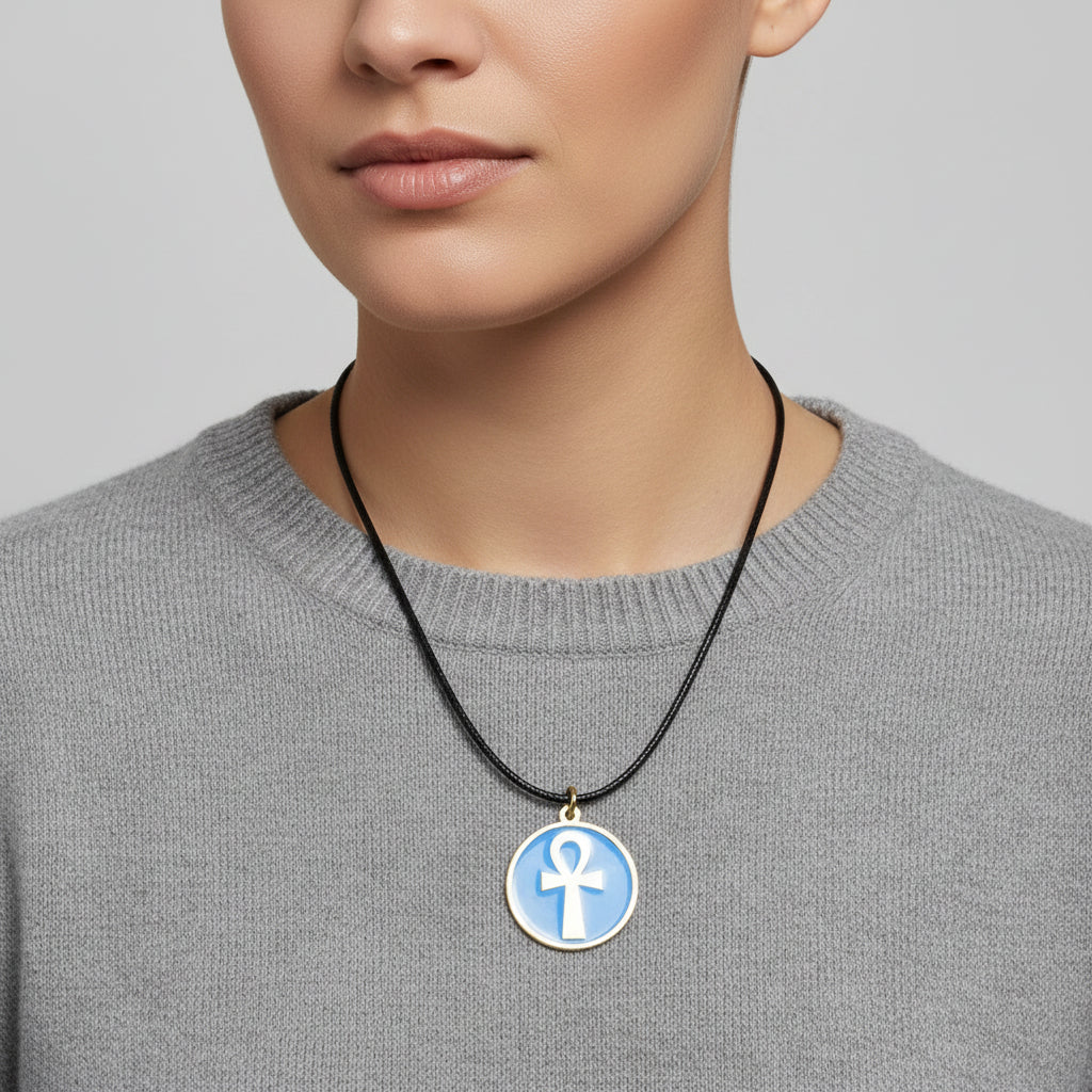 Necklace with a turquoise pendant featuring a gold ankh symbol, handmade of brass