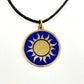 Fair trade handmade brass pendant featuring gold sun against blue enamel on black cord