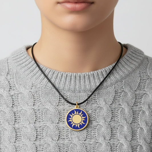 Necklace with a handmade brass pendant featuring gold sun against blue enamel, fair trade