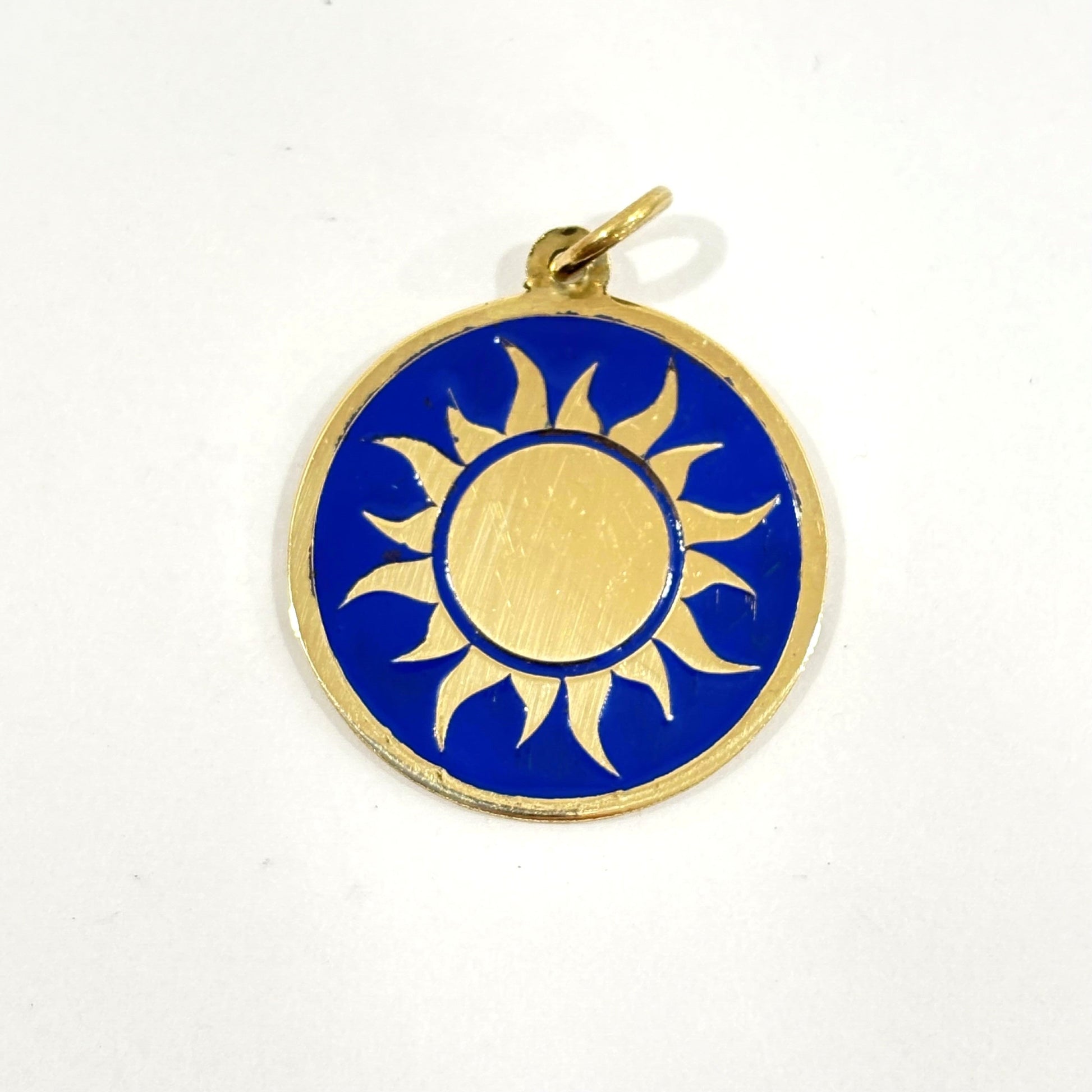Fair trade handmade brass pendant featuring gold sun against blue enamel
