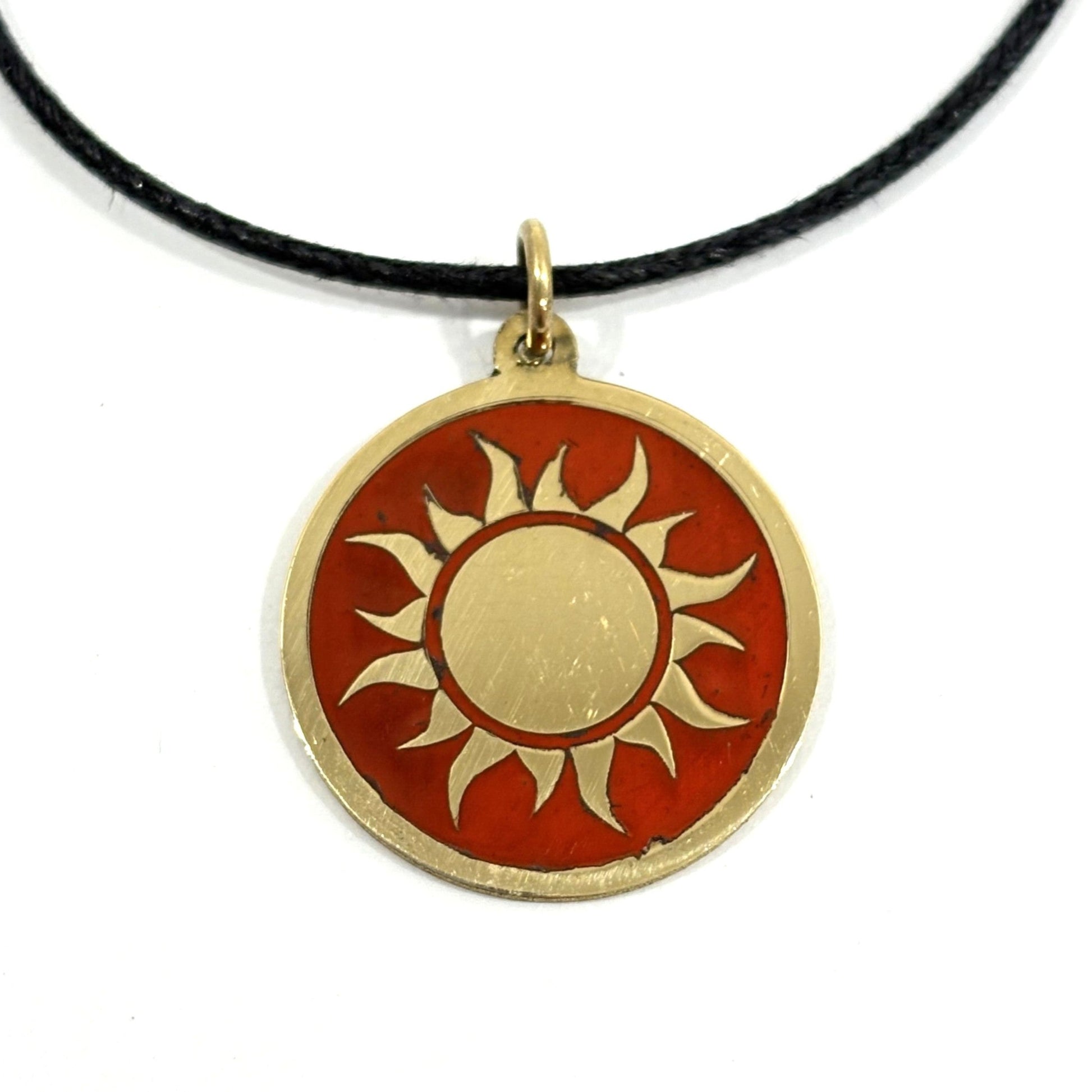 Fair trade handmade brass pendant featuring gold sun against maroon enamel on black cord