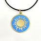 Handmade brass gold sun pendant on a turquoise blue enamel background with a black cord