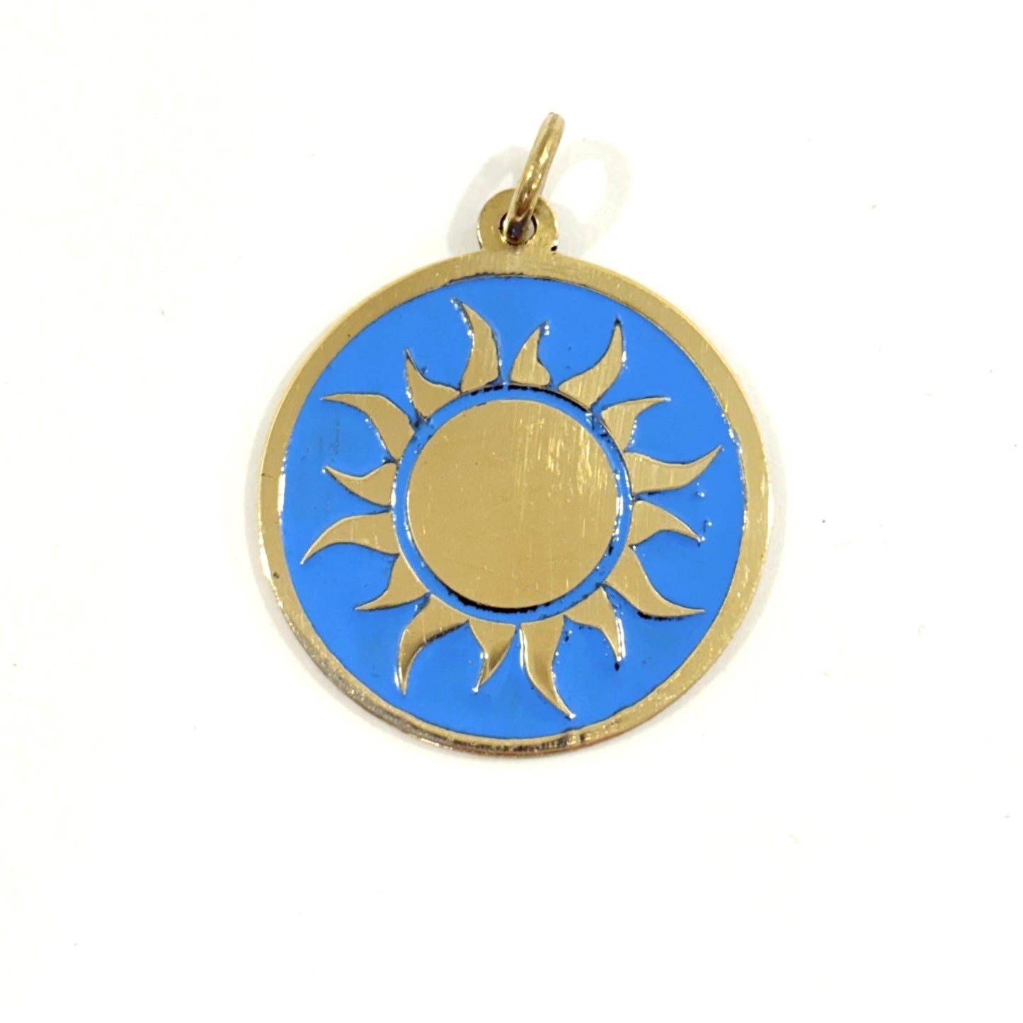Handmade brass gold sun pendant on a turquoise blue enamel background
