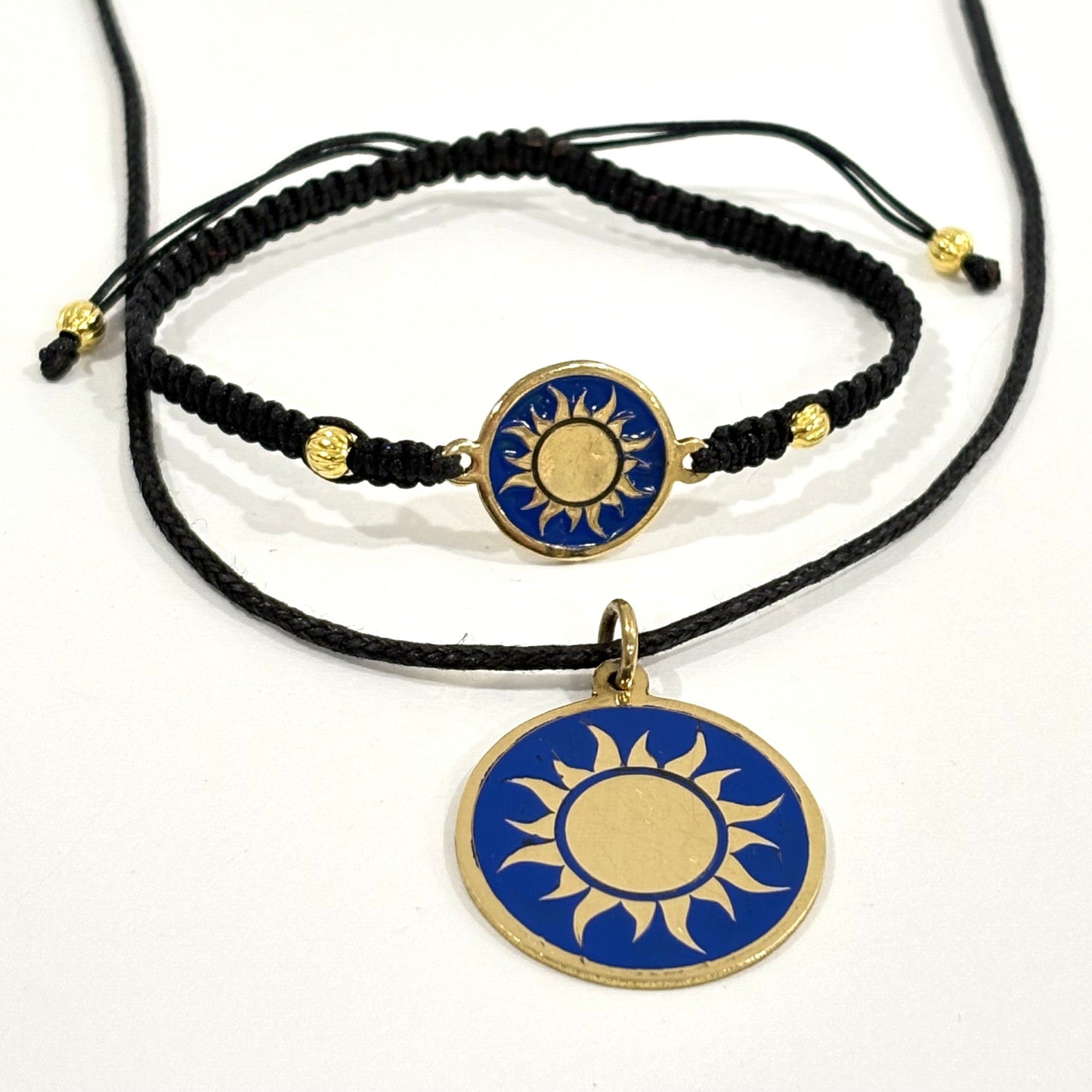 Necklace with a handmade brass pendant featuring gold sun against blue enamel and black macrame bracelet with matching medallion, fair trade