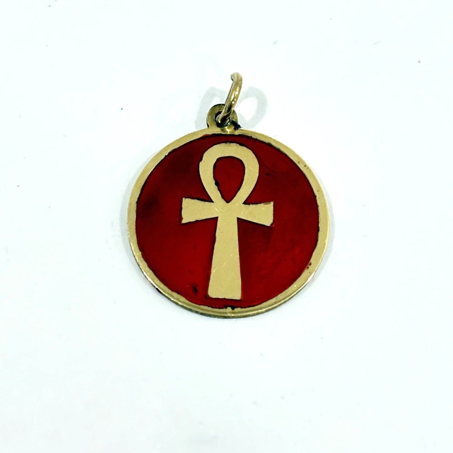 Necklace with a maroon red pendant featuring a gold ankh symbol, handmade of brass