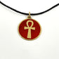 Necklace with a maroon red pendant featuring a gold ankh symbol, handmade of brass