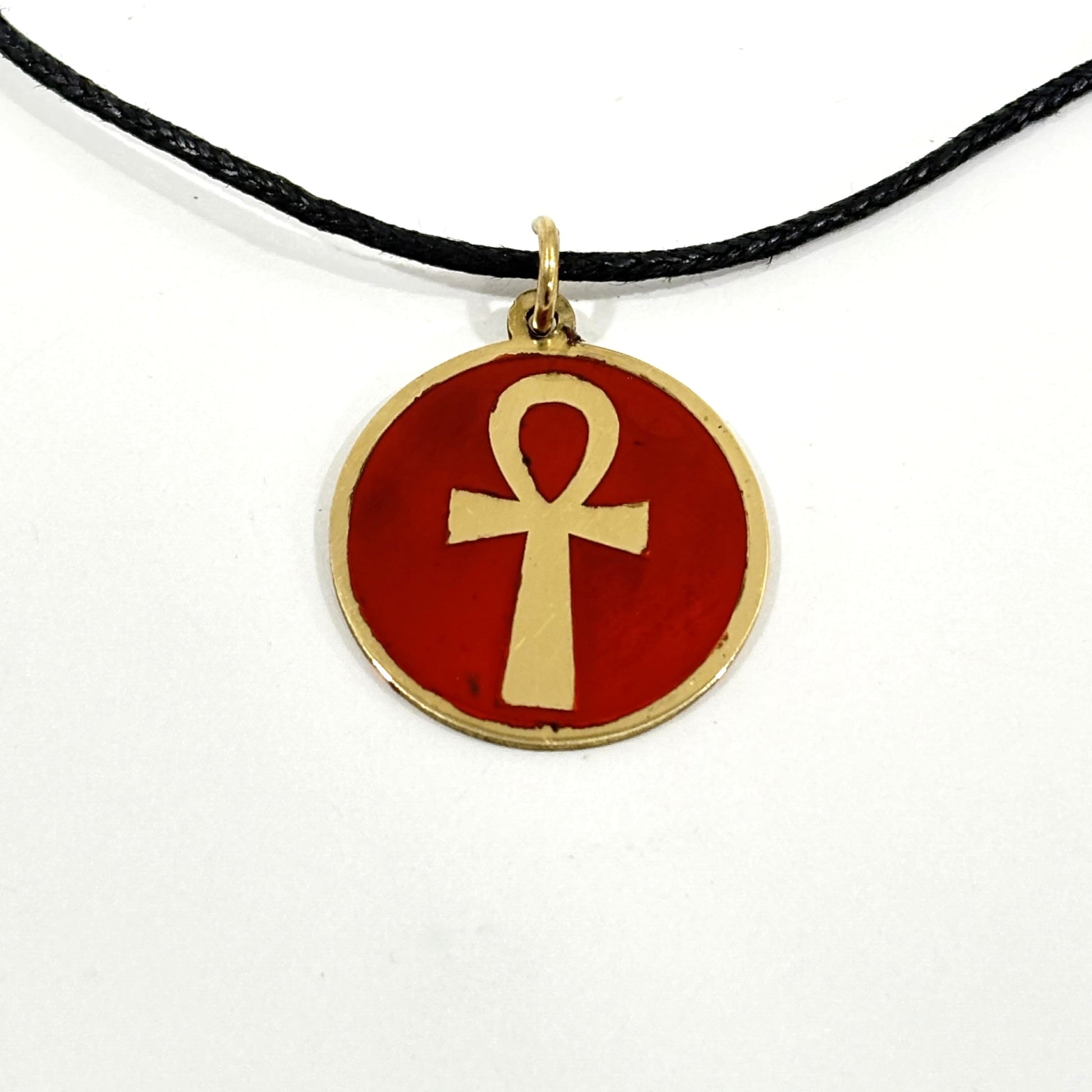 Necklace with a maroon red pendant featuring a gold ankh symbol, handmade of brass