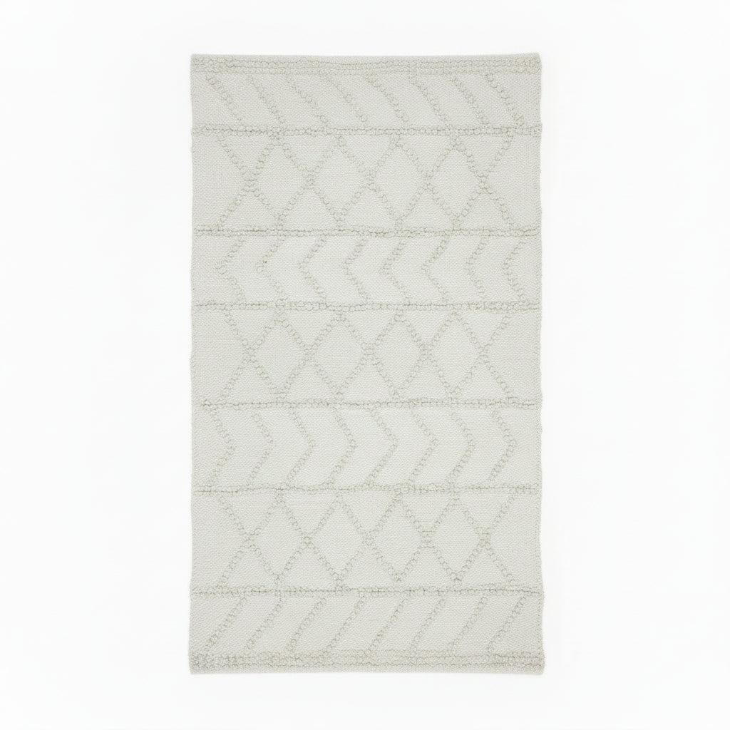 Rectangular handwoven kilim rug in a warm off-white, featuring a textured geometric chevron and diamond pattern