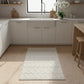 Rectangular handwoven kilim rug in a warm off-white, featuring a textured geometric chevron and diamond pattern