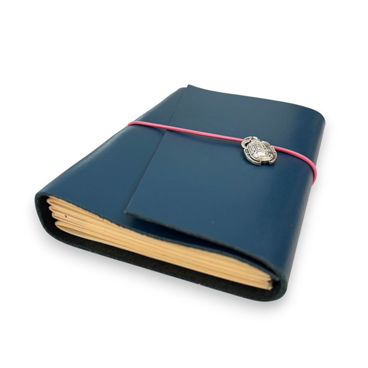 Handbound dark blue leather journal with a diagonal fold closure, secured by an elastic band featuring a silver scarab charm